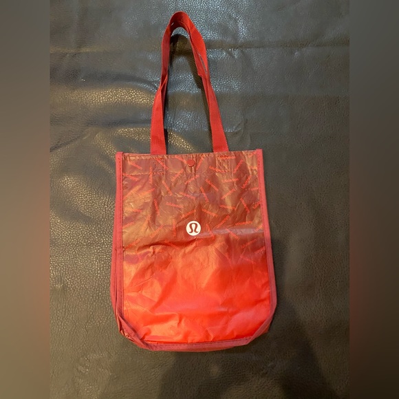 lululemon athletica Handbags - Red ombre Lululemon bag with snap
closure, 100% recycled polypropylene, reusable